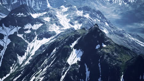 Antena-Sobre-El-Valle-Con-Montañas-Cubiertas-De-Nieve-En-La-Distancia
